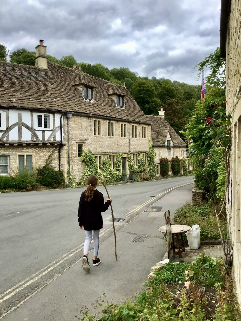 Girl walking through Castle Combe 